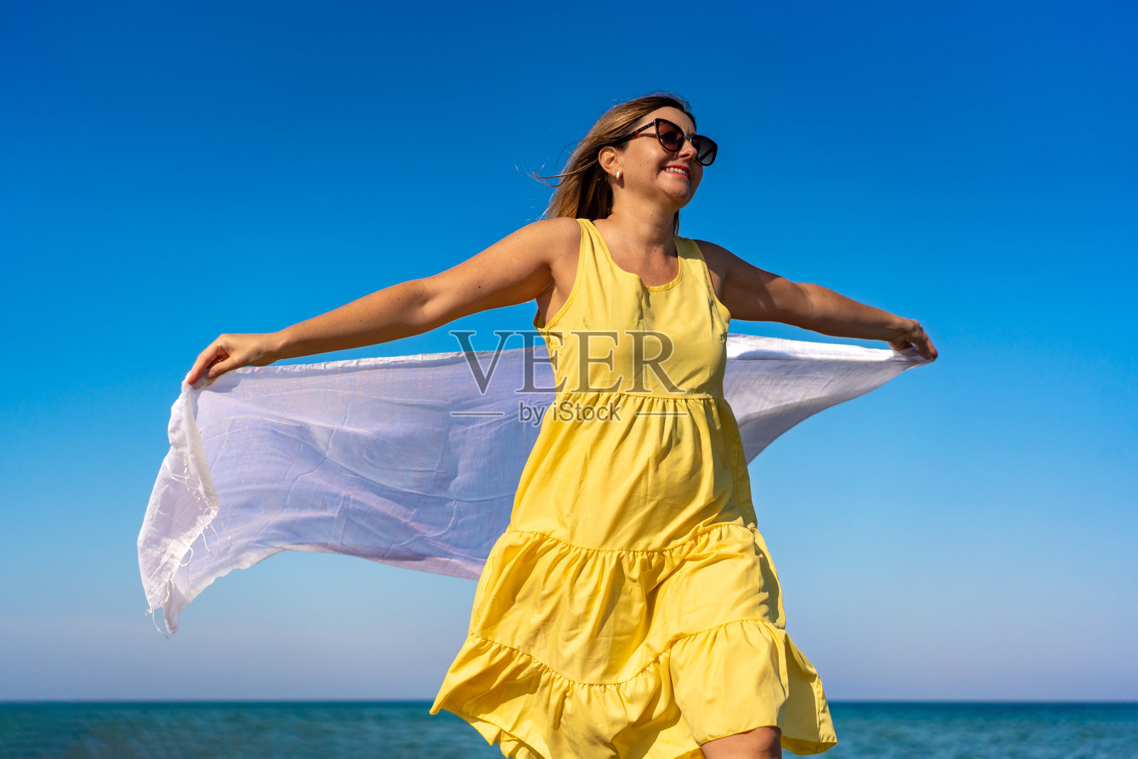 美丽的女人走在沙滩上照片摄影图片