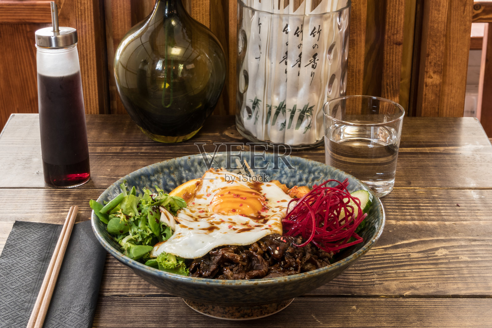 木桌上的韩式拌饭加鸡蛋。照片摄影图片