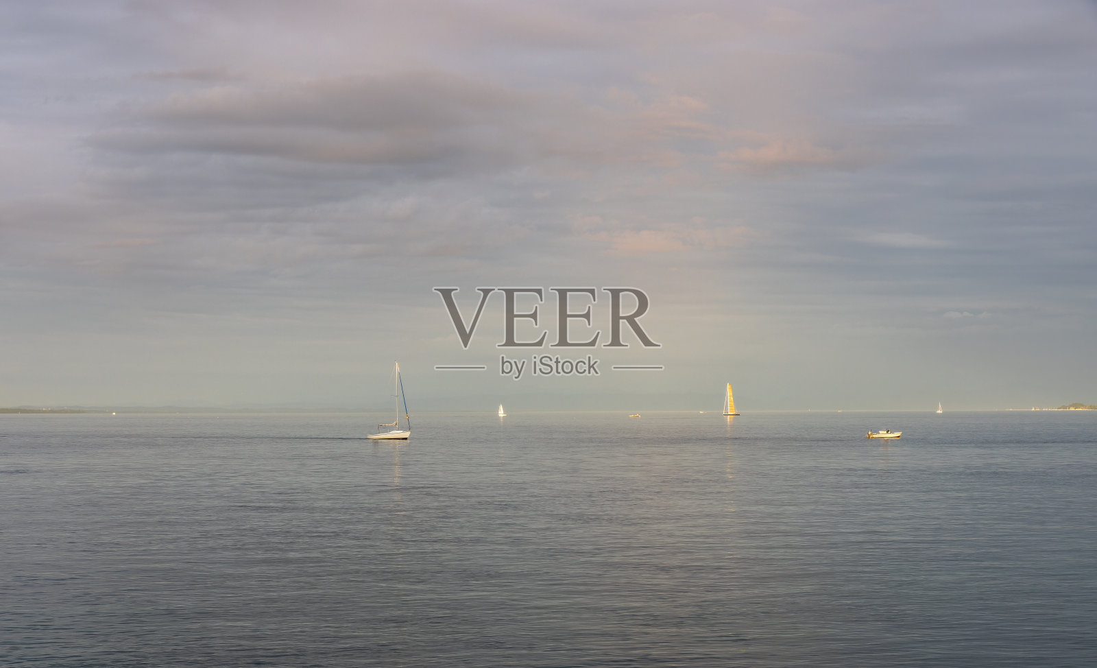 在日落的黄金时刻，康士坦茨湖上有帆船和游艇照片摄影图片