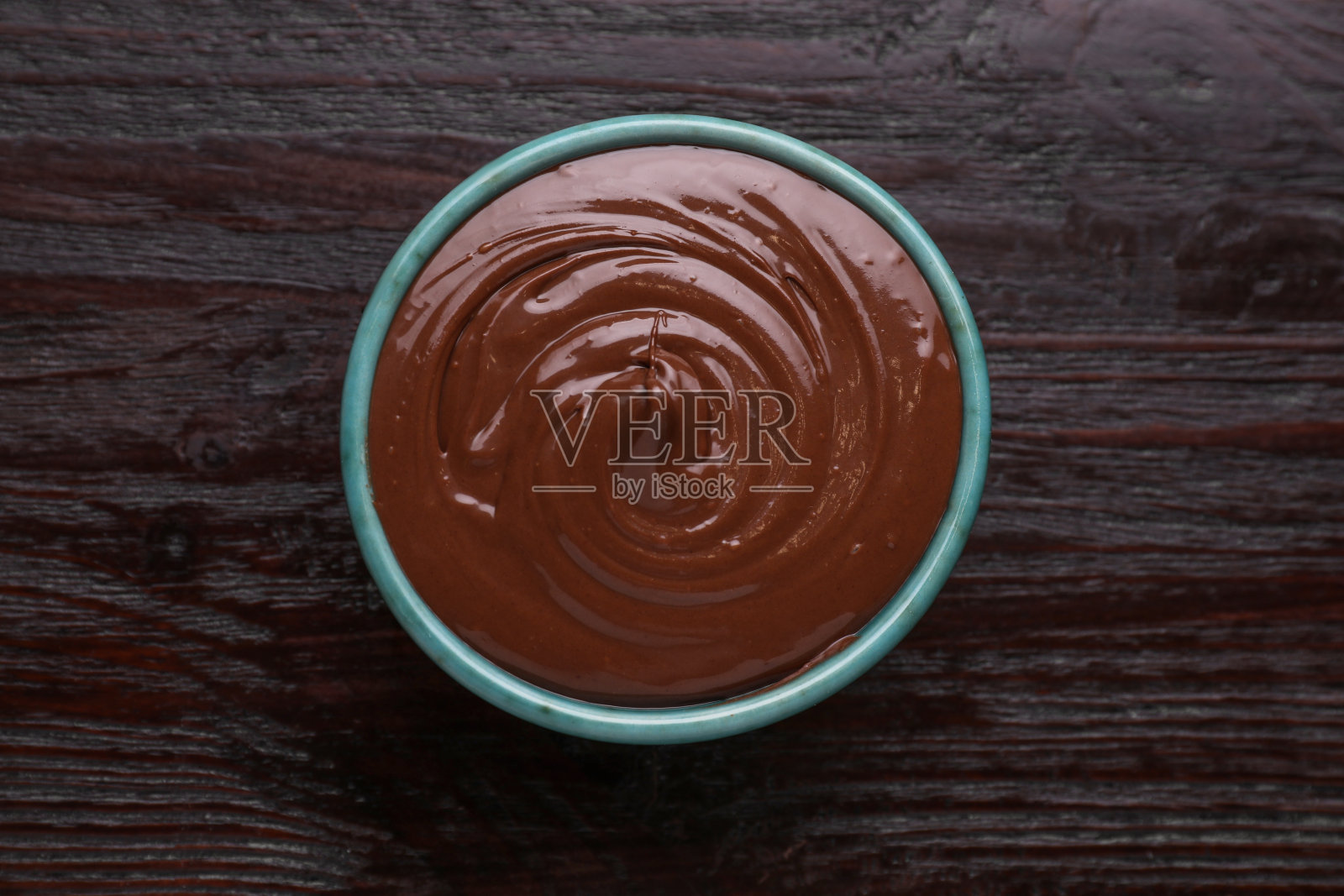木桌上的碗里有美味的巧克力酱，俯视图照片摄影图片