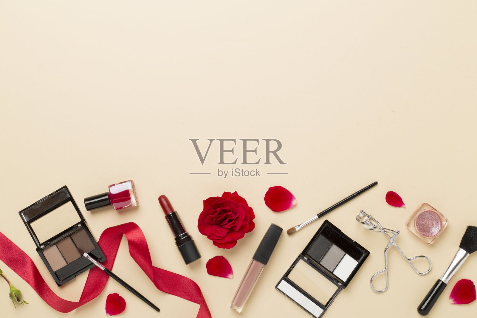 平躺着化妆产品和工具，彩色背景上有鲜花照片摄影图片