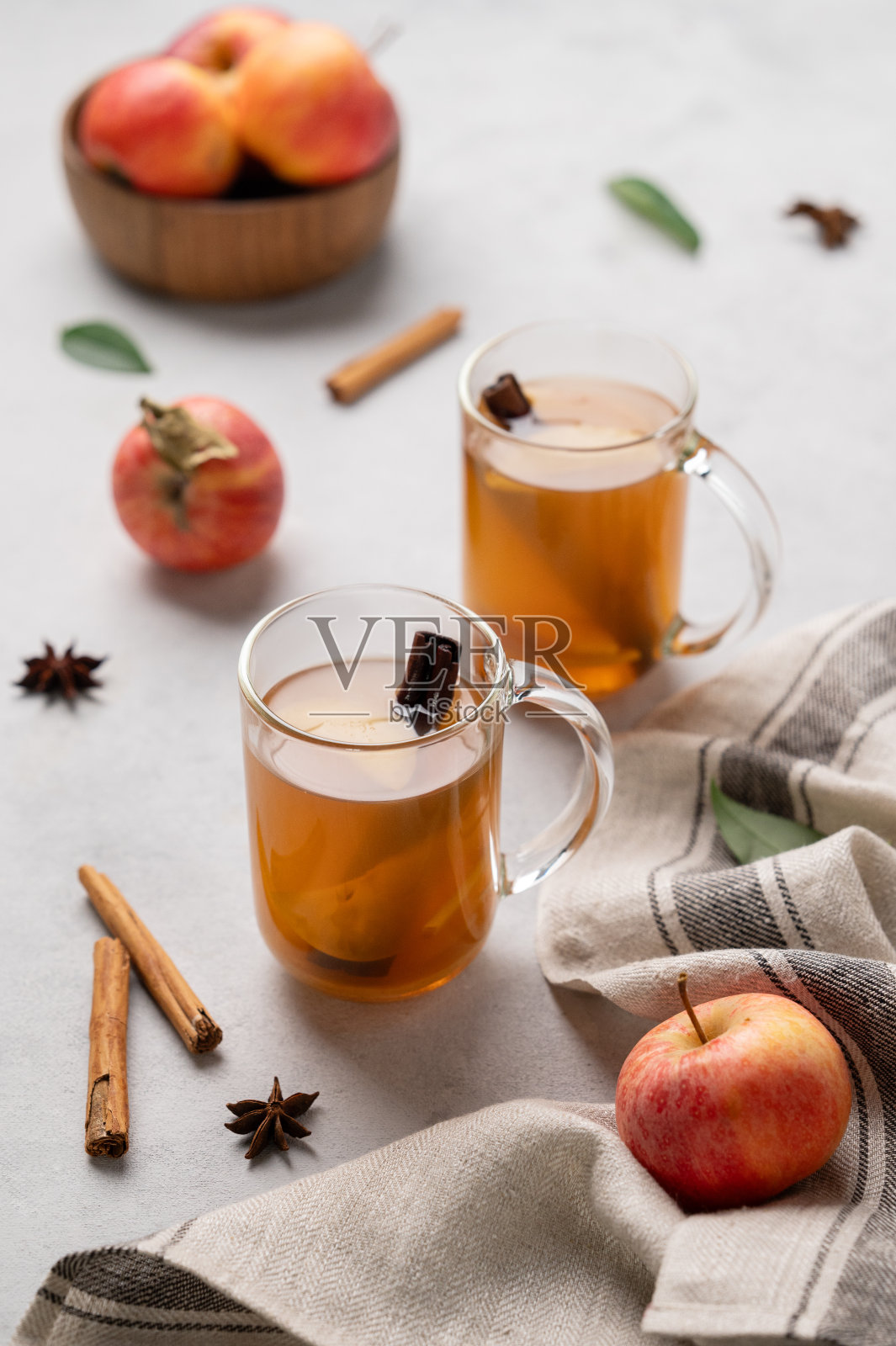 自制苹果酒，配以苹果和肉桂，淡色背景，配以新鲜水果和香料。照片摄影图片