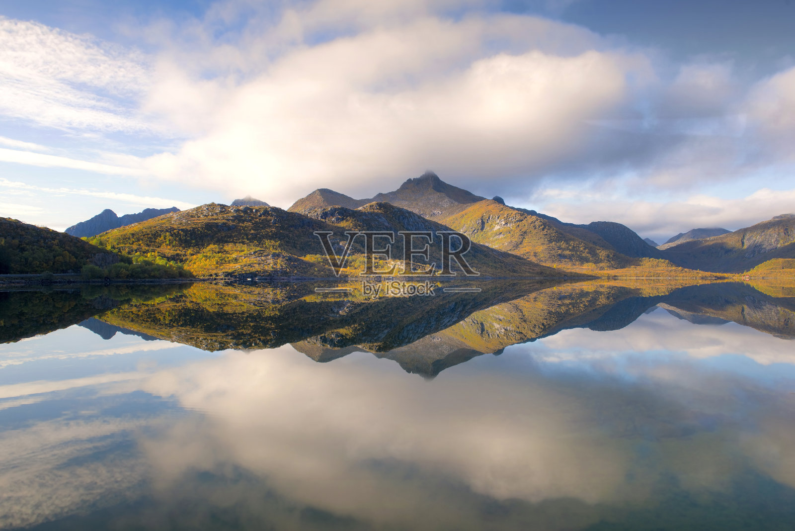 挪威美丽的山峦映照在水面上，就像一面镜子照片摄影图片