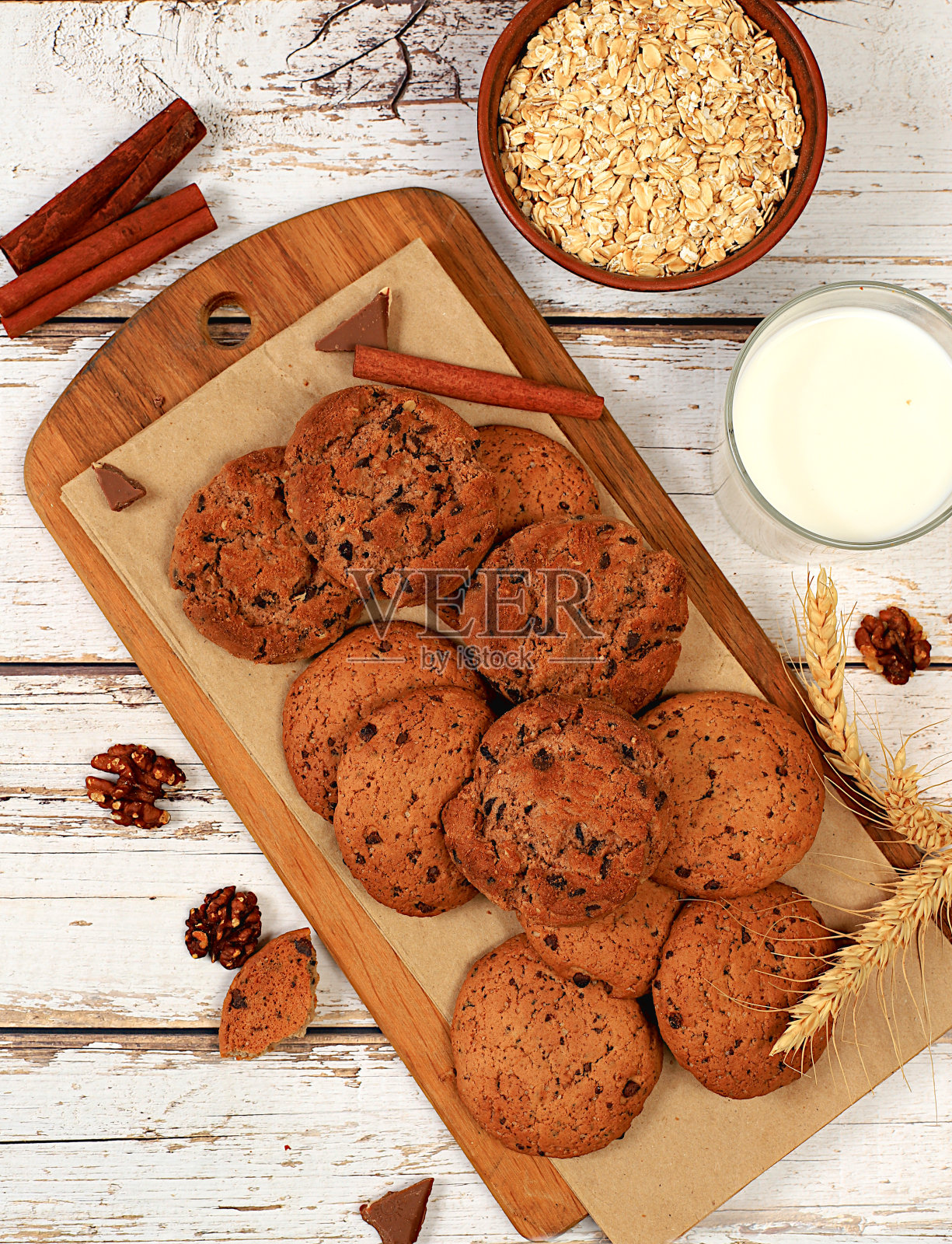 自制巧克力片和坚果无麸质燕麦饼干与耳朵木制背景，现代面包店和谷物食品的概念。健康早餐配食材，俯视图，照片摄影图片