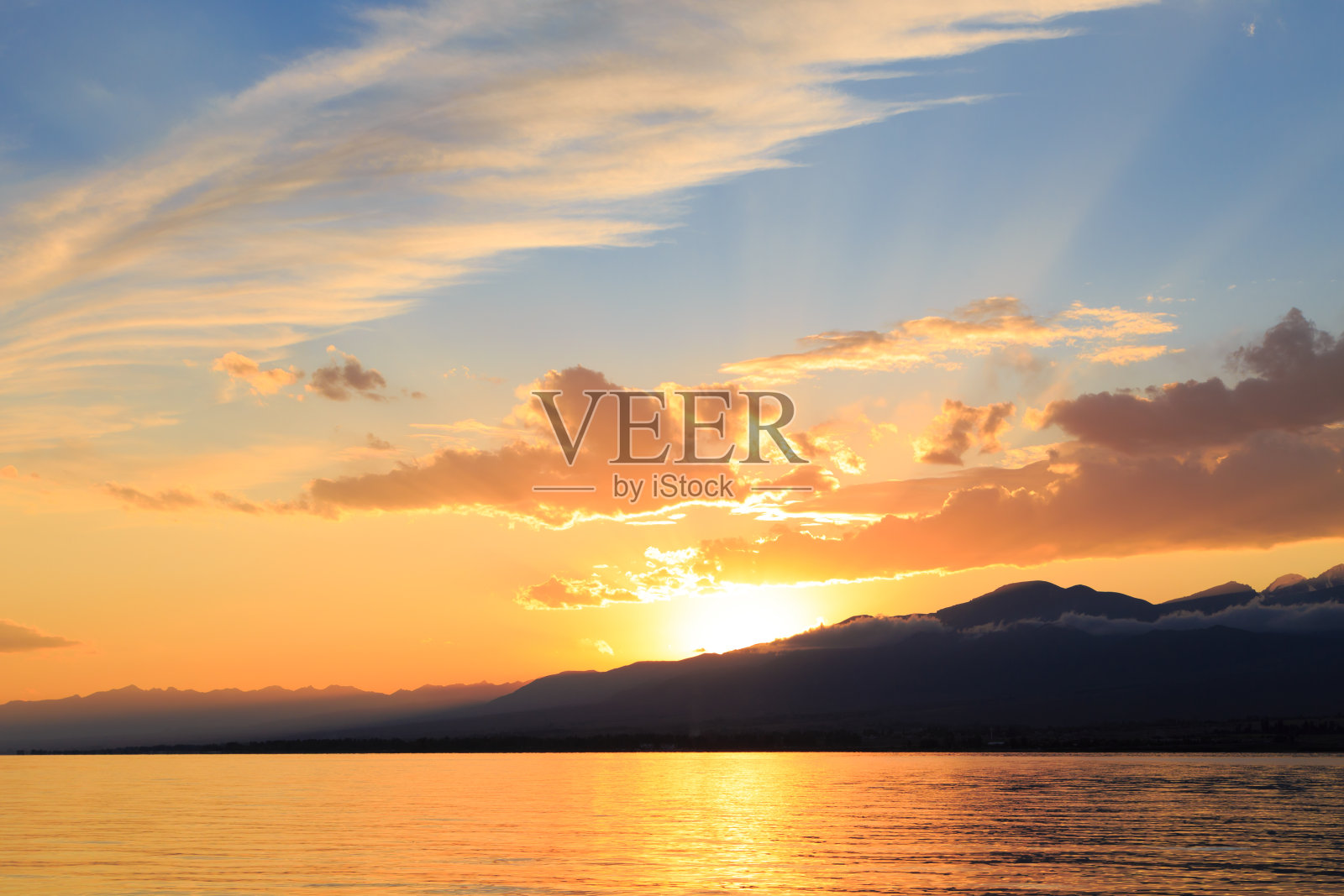 五彩缤纷的海滩在山日出与深蓝色的天空和阳光。自然背景照片摄影图片