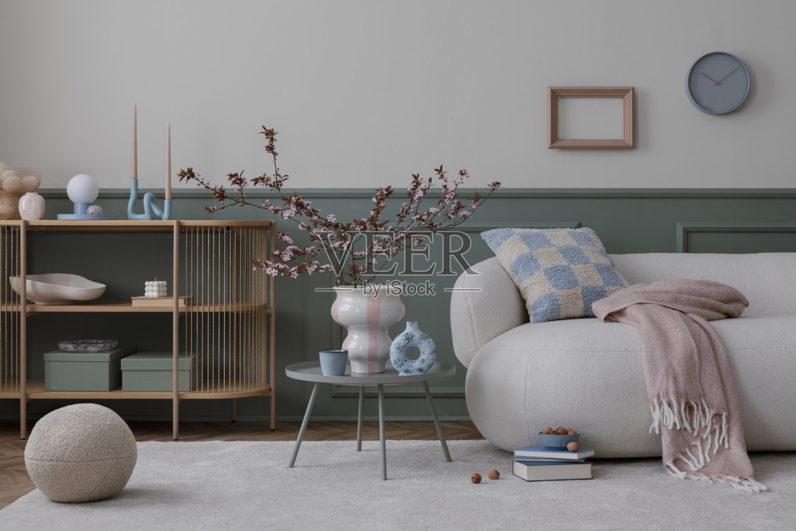 室内设计舒适的客厅室内与模拟海报框架，圆形沙发，咖啡桌，花瓶与开花的树枝，图案枕头和个人配件。家居装饰。模板。照片摄影图片