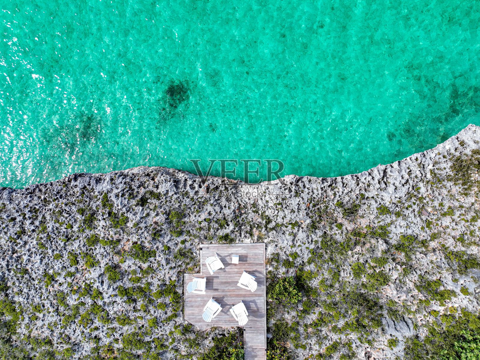 从一架无人驾驶飞机上拍摄的非凡景色，宁静的甲板坐落在岩石海岸上。照片摄影图片
