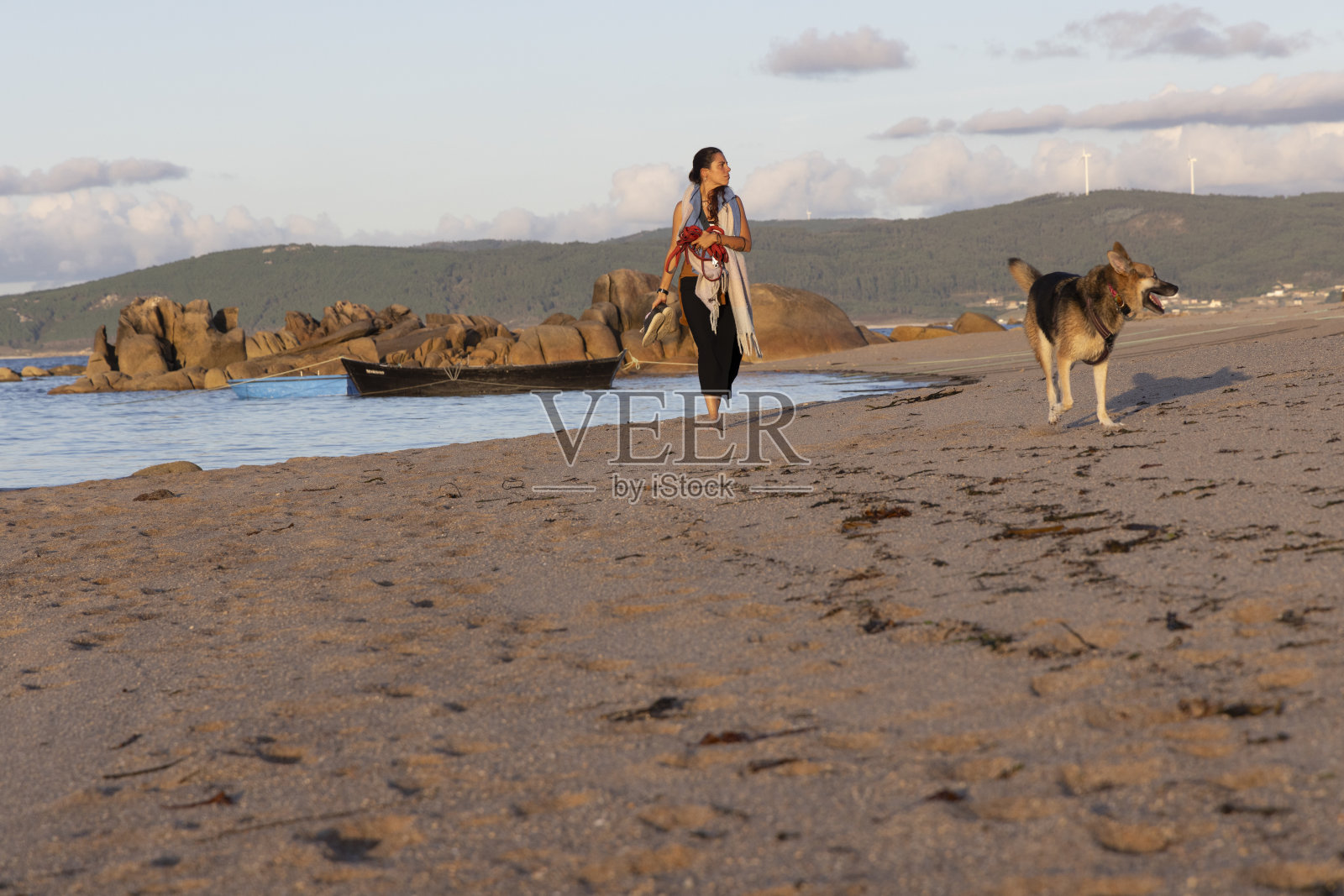 狗和女人在沙滩上散步照片摄影图片