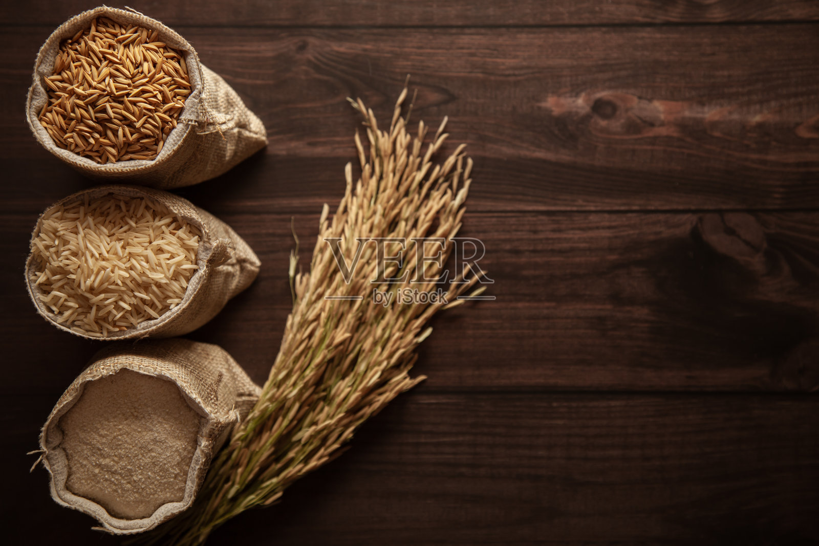 三个不同阶段的有机水稻(Oryza sativa)在一个黄麻袋。采购产品米糠，大米和米粉。照片摄影图片