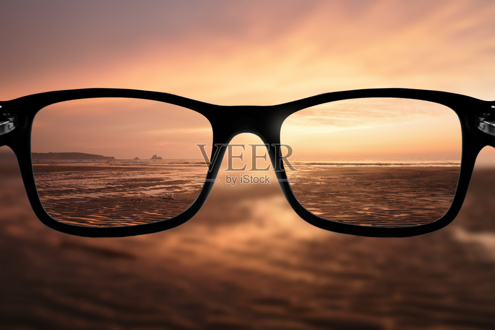 日落时聚焦海滩的眼镜照片摄影图片