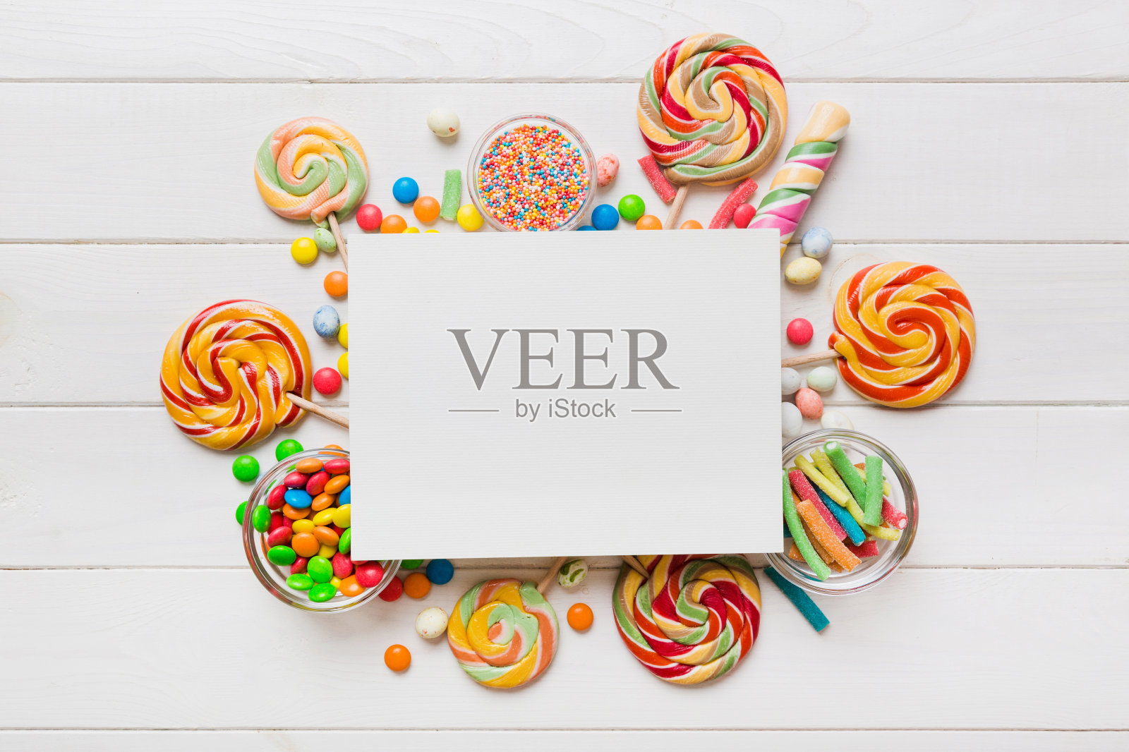 平铺假日构图。白纸，棒棒糖，生日装饰彩色背景。俯视图，文本复制空间照片摄影图片