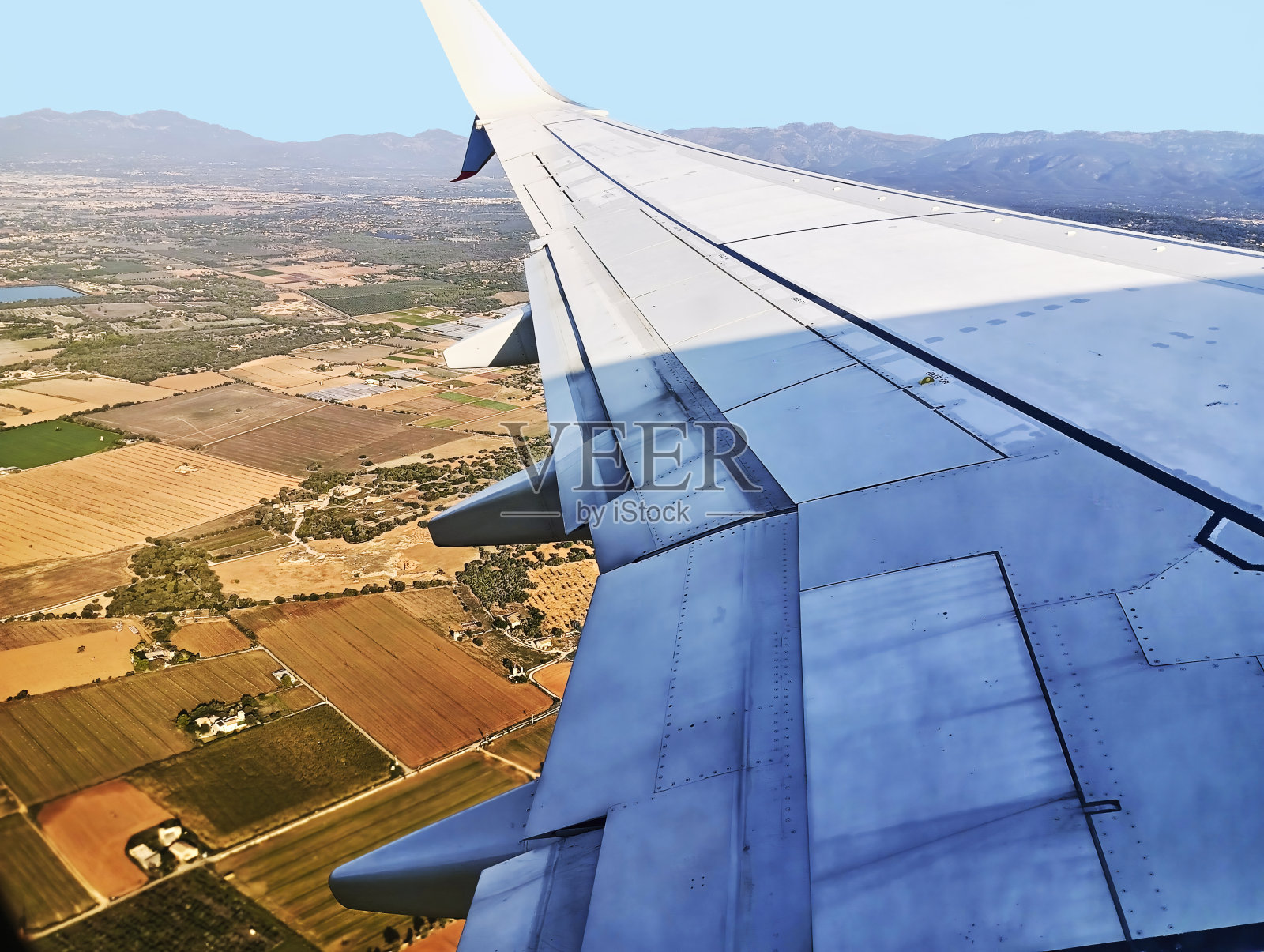 从一架客机的机翼上俯瞰地中海巴利阿里群岛马略卡岛地平线上的田野和山脉照片摄影图片