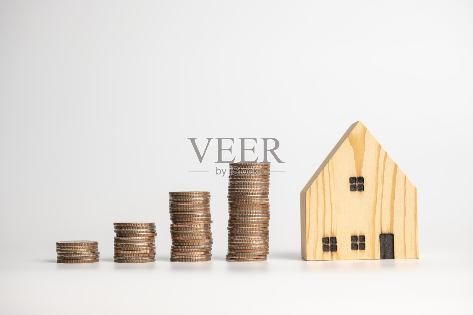 房地产投资和省钱的理念。硬币堆叠与房子的图标和背景。照片摄影图片