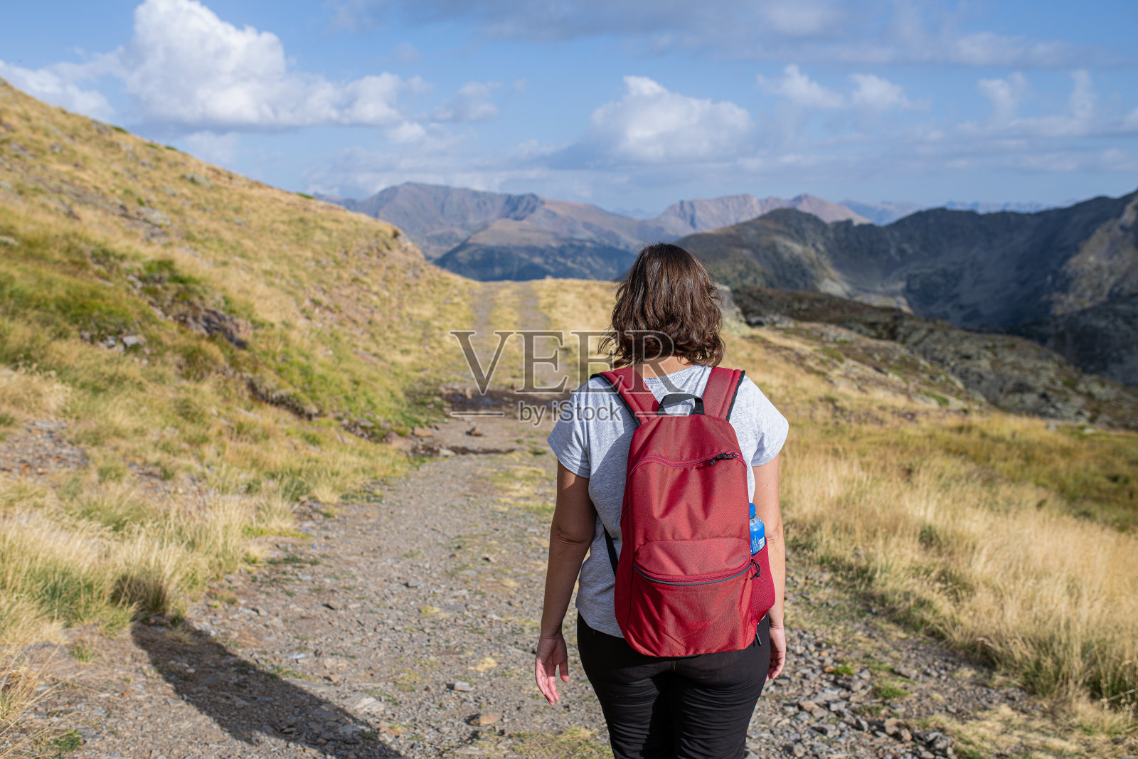 年轻的高加索女孩沿着山间的小路走着照片摄影图片