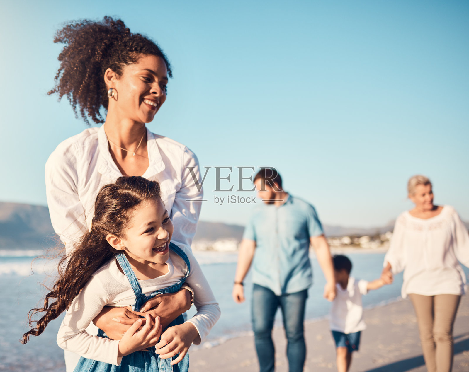 母亲，孩子和户外玩耍在海滩上的家庭度假，假期或冒险在夏天。兴奋的年轻女孩和一个充满活力、快乐和爱的女人在海上度过了美好的时光照片摄影图片