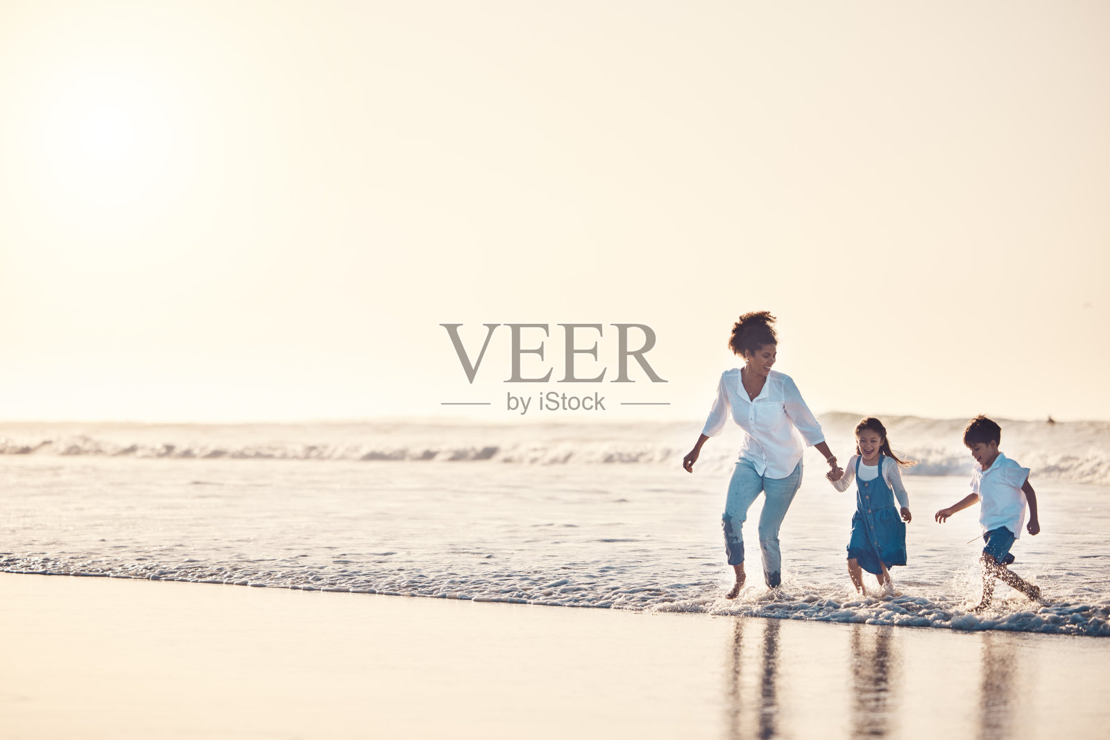 玩耍，母亲和孩子在海滩上一个有趣的家庭度假，假期或自然冒险在日落。年轻的男孩和女孩牵着女人的手在户外寻找乐趣、能量、幸福和横幅空间照片摄影图片