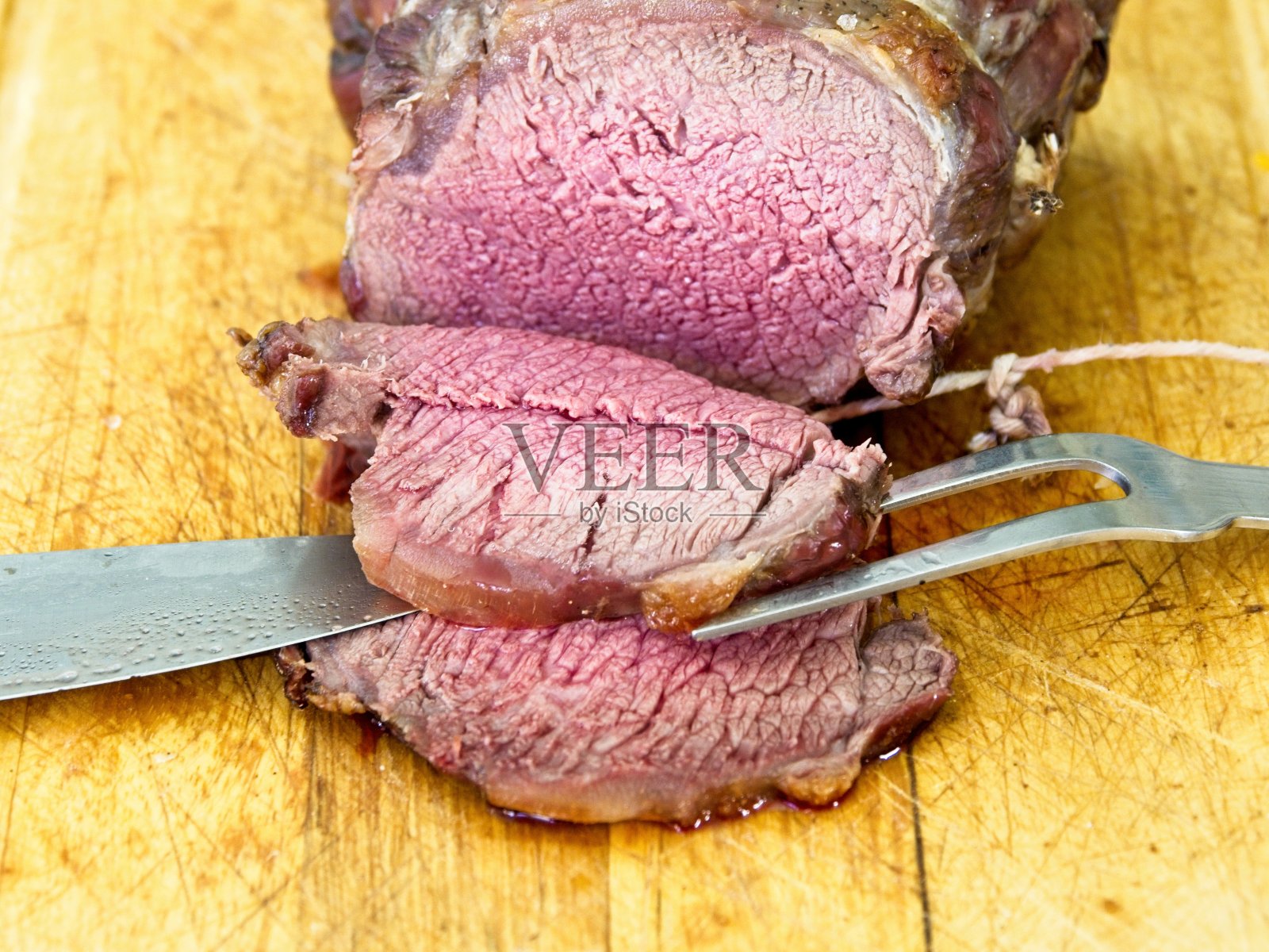 牛肉烤熟至五分熟，放在砧板上照片摄影图片