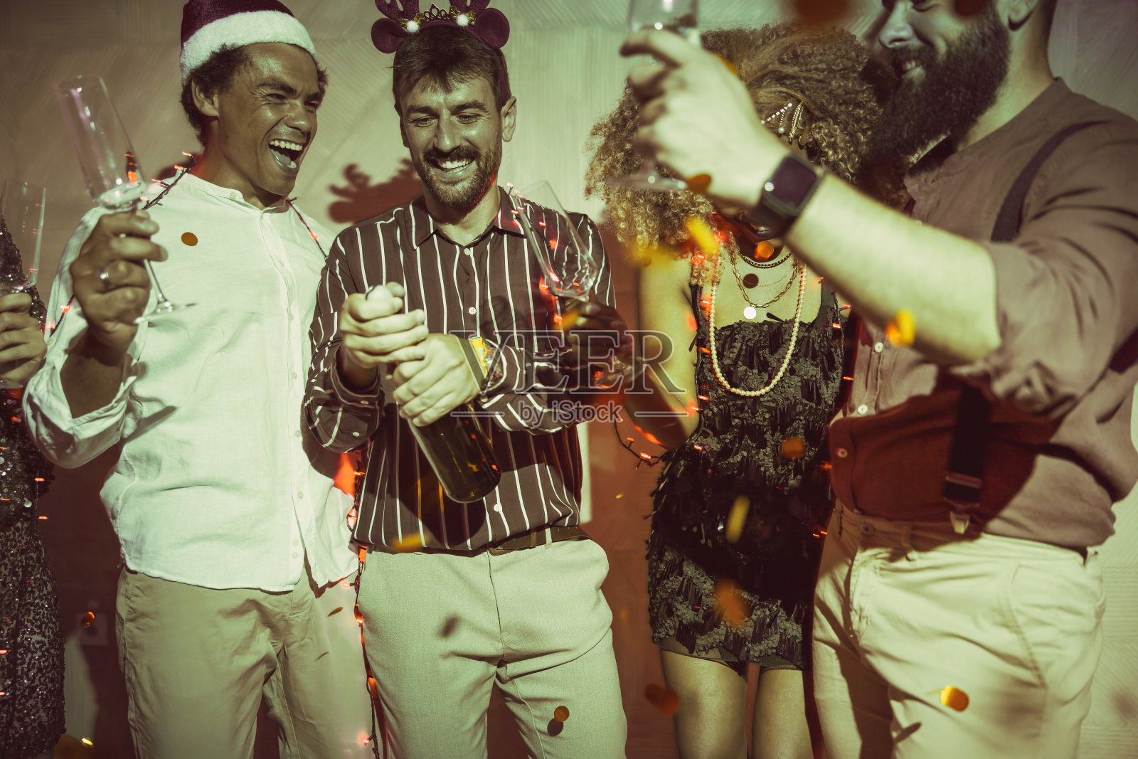 朋友们在新年派对上打开香槟照片摄影图片