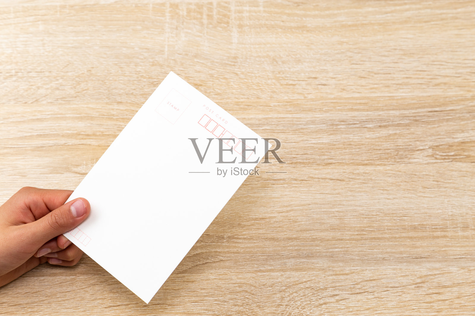 手里拿着明信片。照片摄影图片