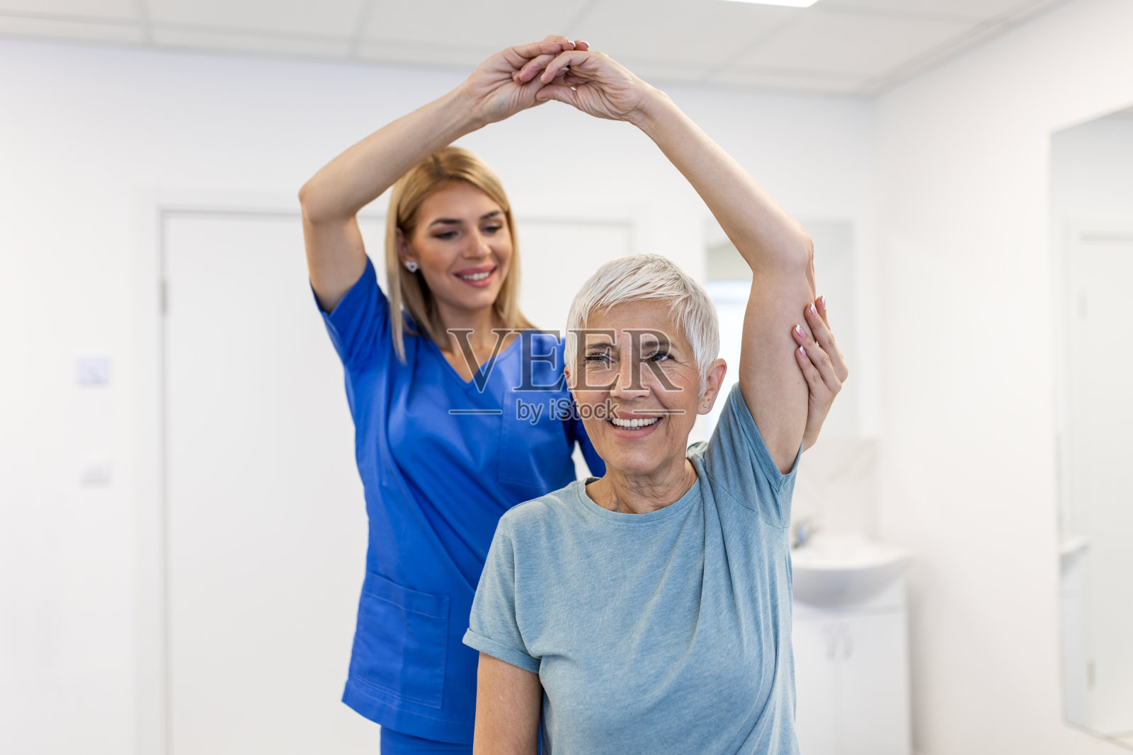 女物理治疗师工作检查治疗老年女性患者的手臂损伤，伸展和运动，在临床做康复治疗疼痛。照片摄影图片