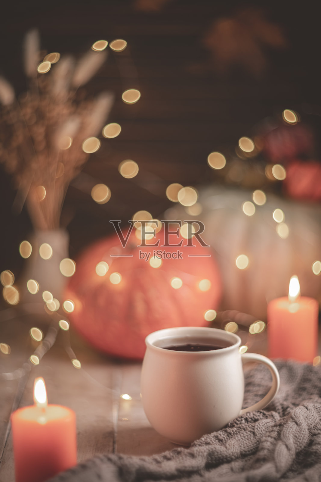 秋天惬意的构图。杯子里的茶，南瓜和蜡烛照片摄影图片