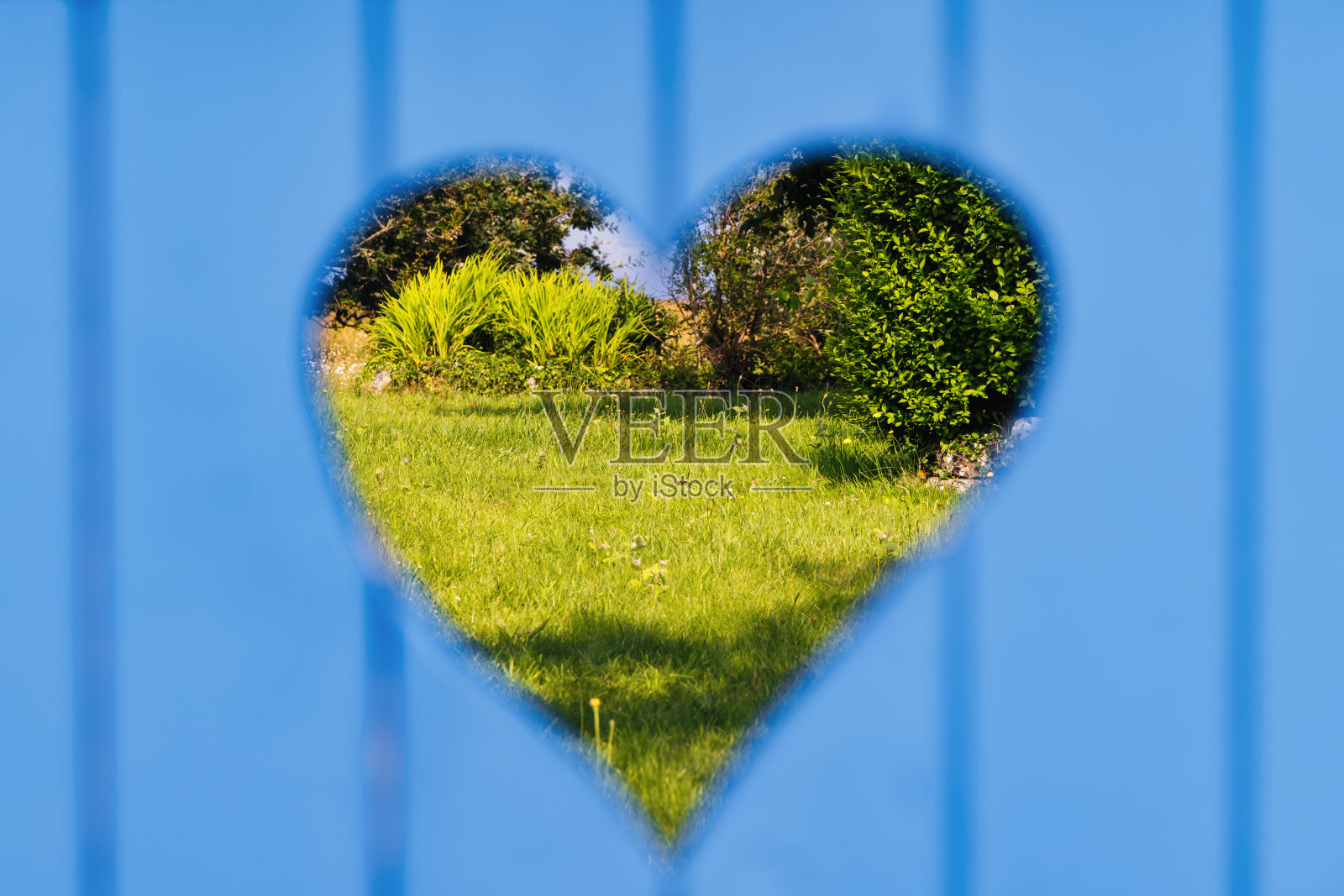 从花园大门的一个心形洞往里看照片摄影图片