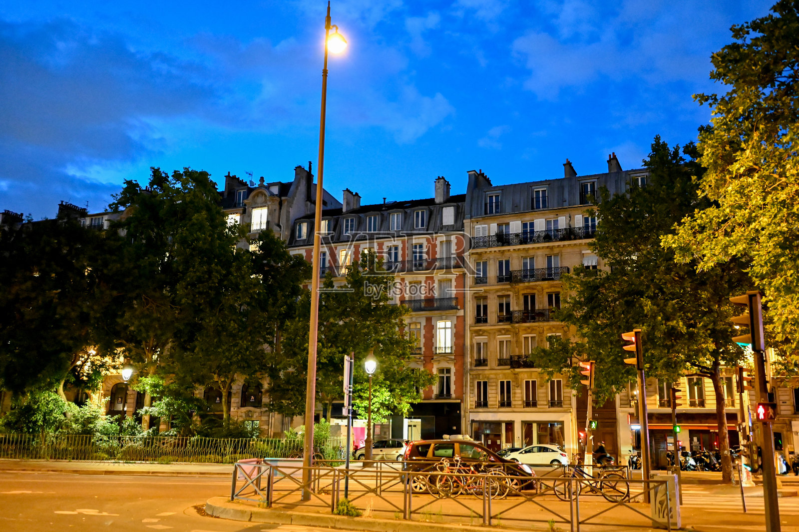 法国巴黎,2022年6月。巴黎的蓝色时光，夜生活的照片。在一个美丽的夏日夜晚，夜晚的灯光笼罩着街道上的人和车。背景是历史建筑照片摄影图片