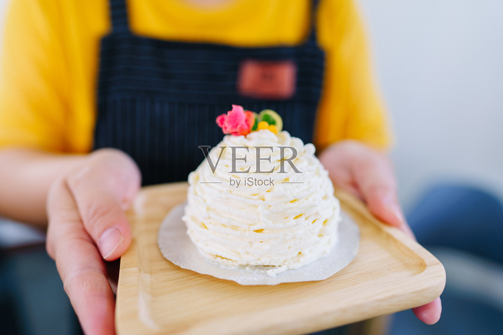 服务员端着盘子里美味的手工蛋糕。照片摄影图片