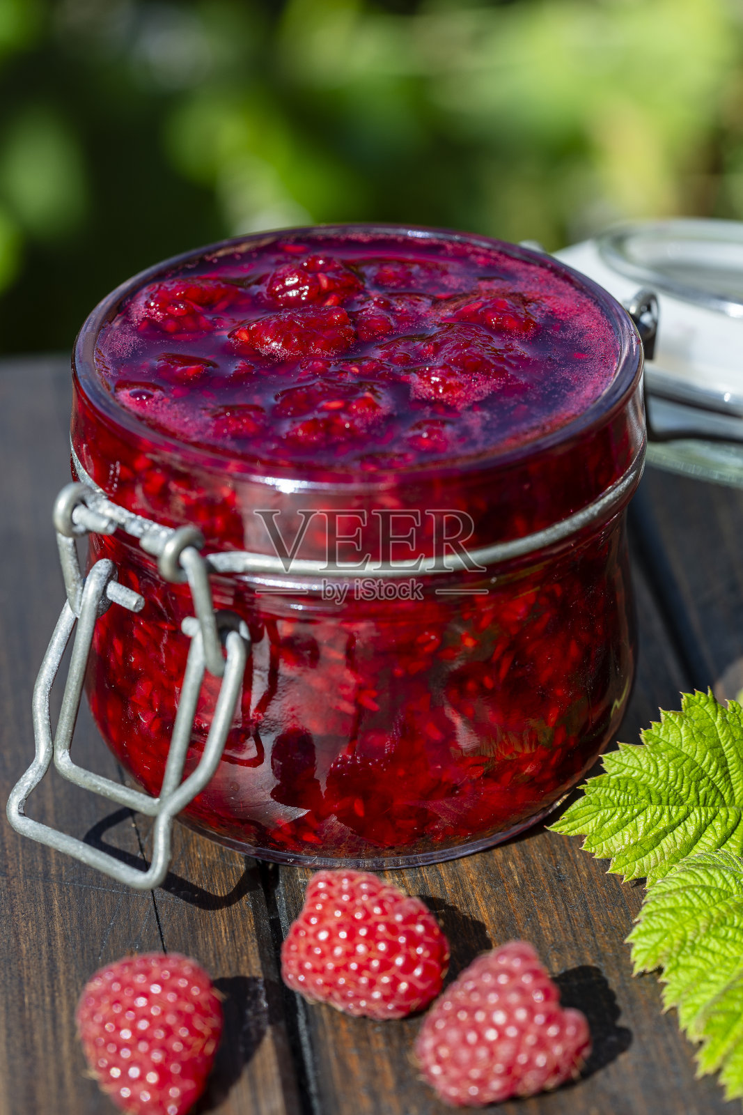 红覆盆子果酱和新鲜覆盆子，室外，靠近花园。乡村风格，特写照片摄影图片