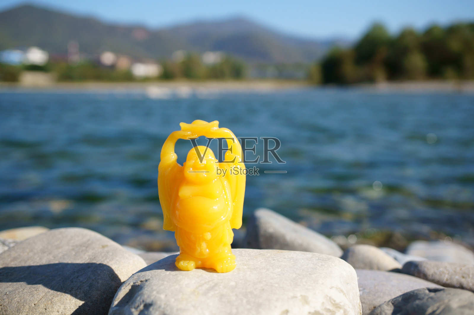 在大海的背景上有一尊微笑的佛像。休息和放松。照片摄影图片