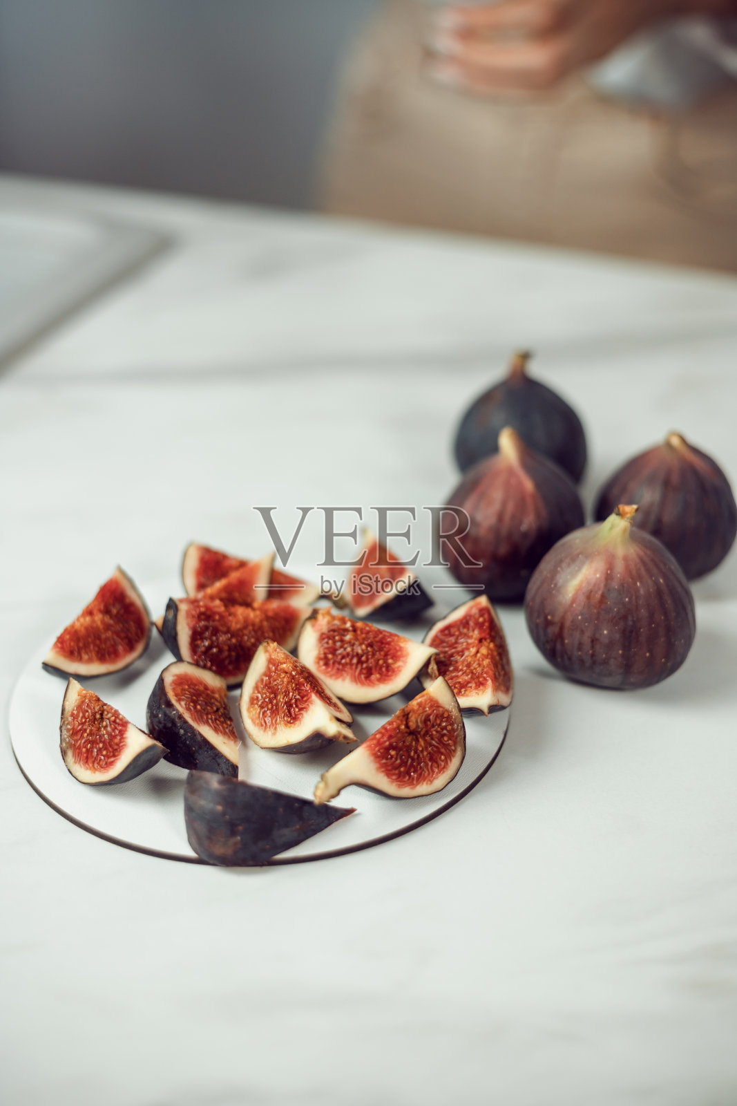 成熟和甜的无花果切好，放在盘子里，白色的背景上有自由的空间。水果和素食主义照片摄影图片