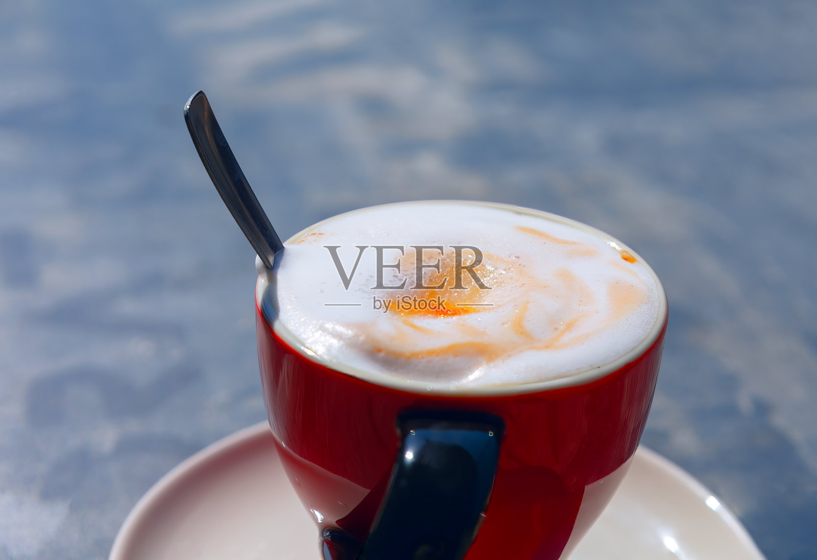 用勺子喝卡布奇诺照片摄影图片