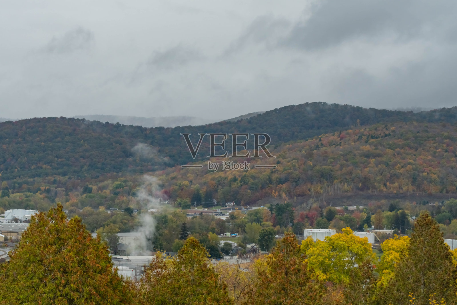 阴沉沉的秋日，从山顶俯瞰布拉德福德镇，位于山谷中的炼油镇。照片摄影图片