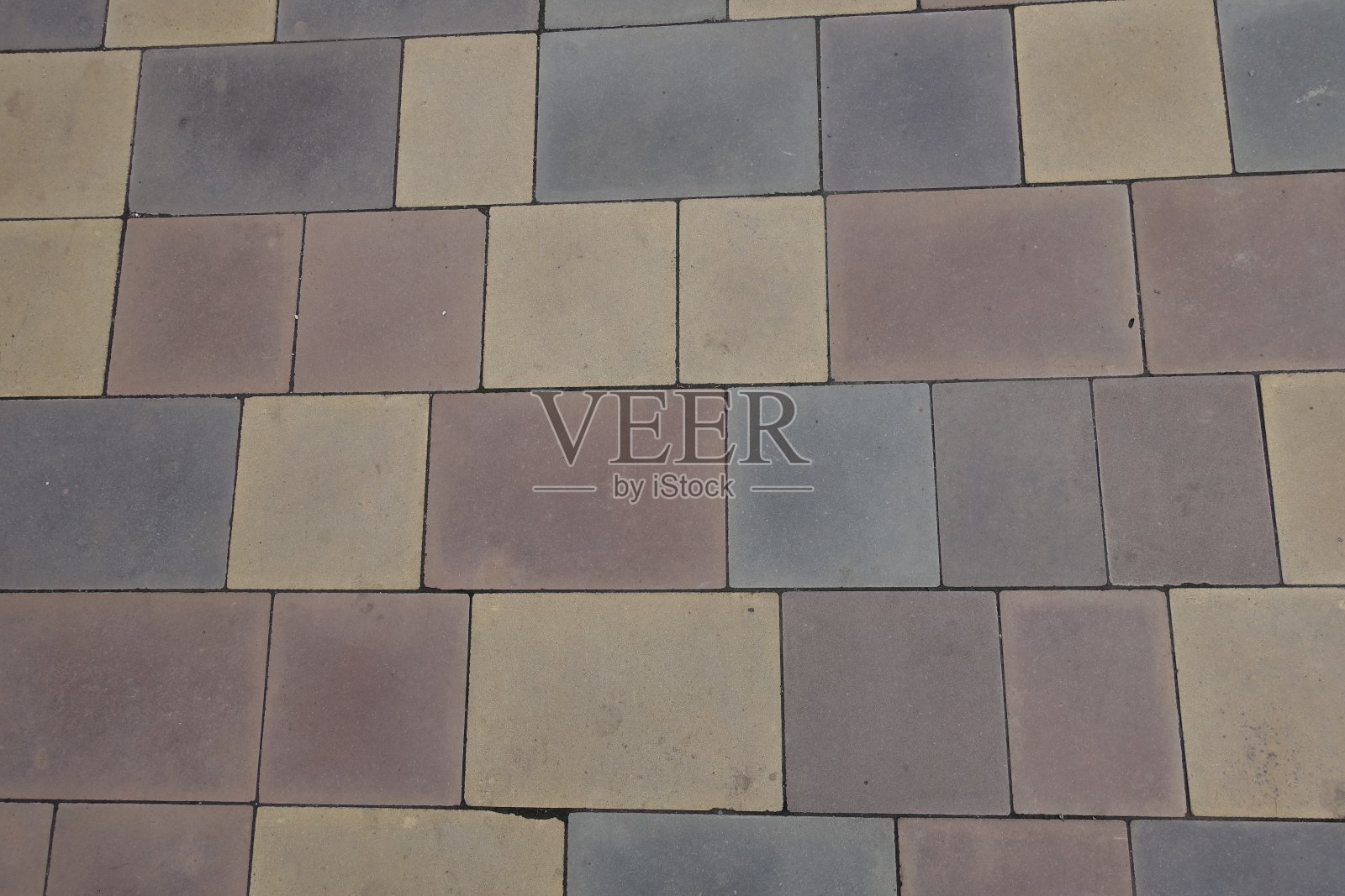 布满灰尘的路面由粉色、黄色、棕色和灰色的混凝土块组成照片摄影图片