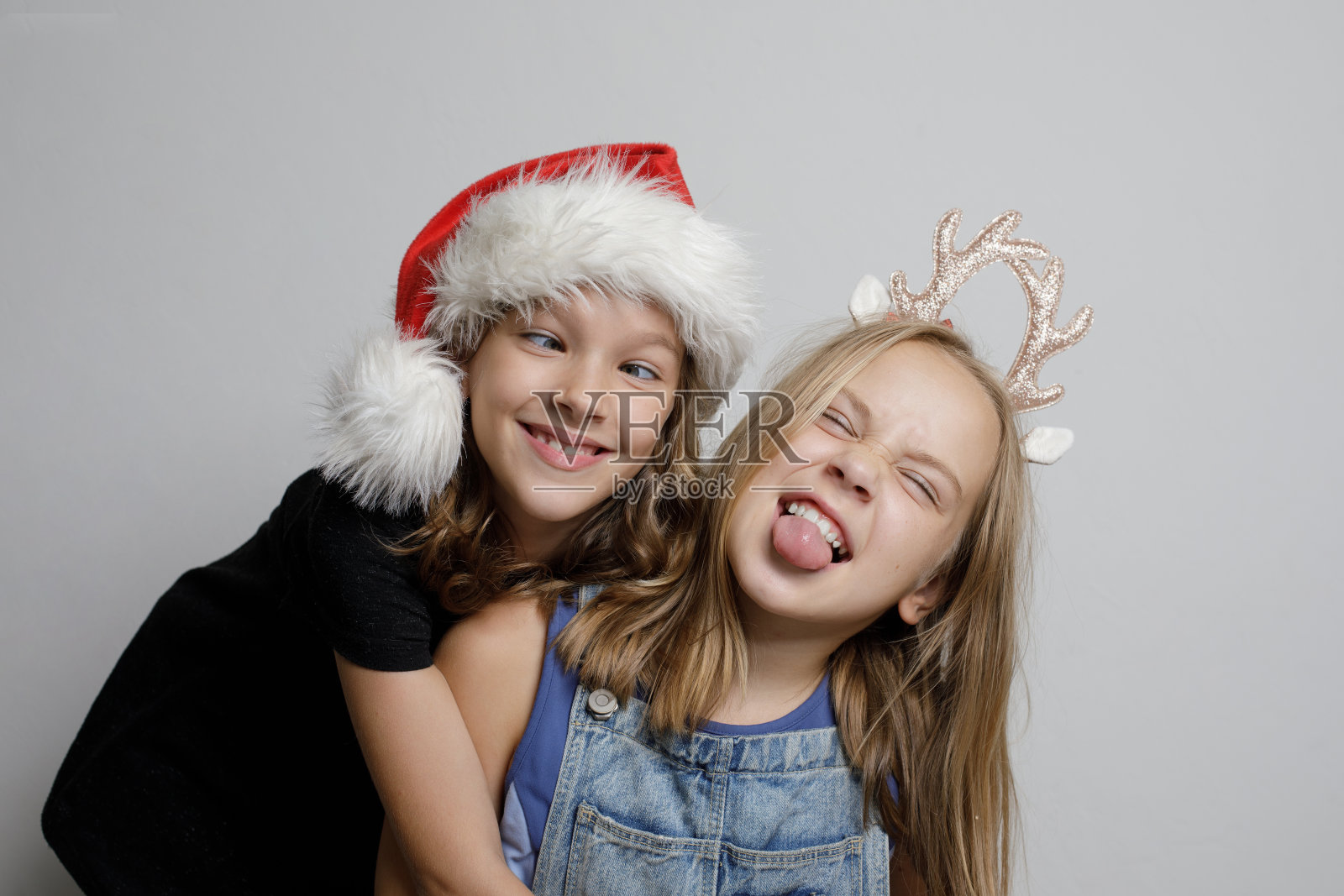 有趣的快乐的孩子女孩最好的朋友姐妹鬼脸和有乐趣的白色背景，圣诞工作室肖像照片摄影图片