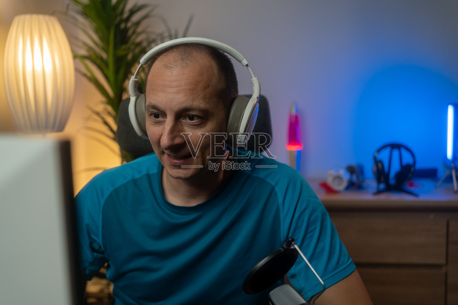 玩家戴着耳机在暗室里玩在线视频游戏照片摄影图片