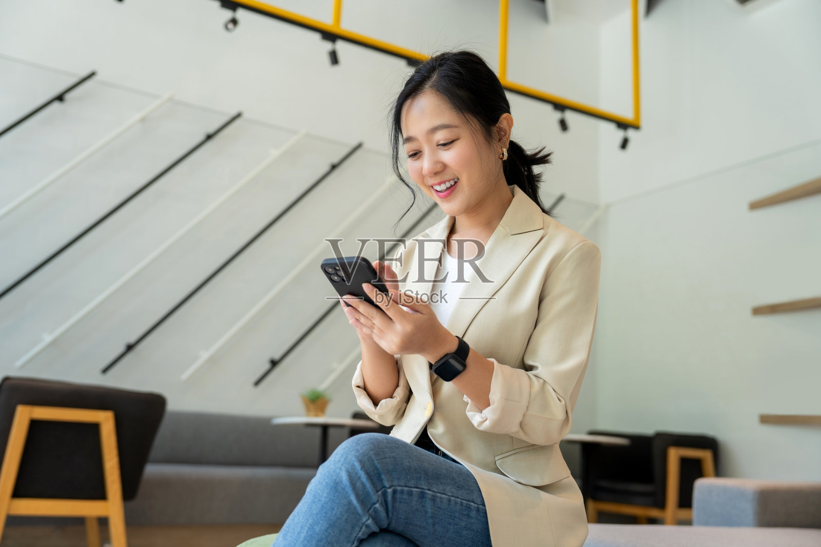 自由亚洲女性用智能手机在线工作。照片摄影图片