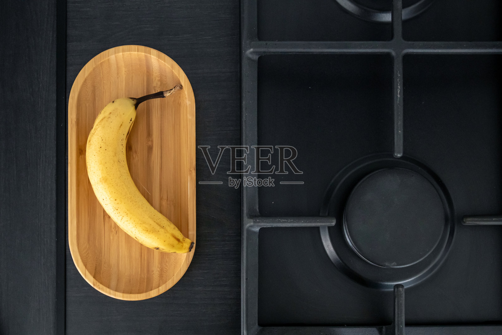 熟了的黄香蕉在厨房水槽旁边。照片摄影图片