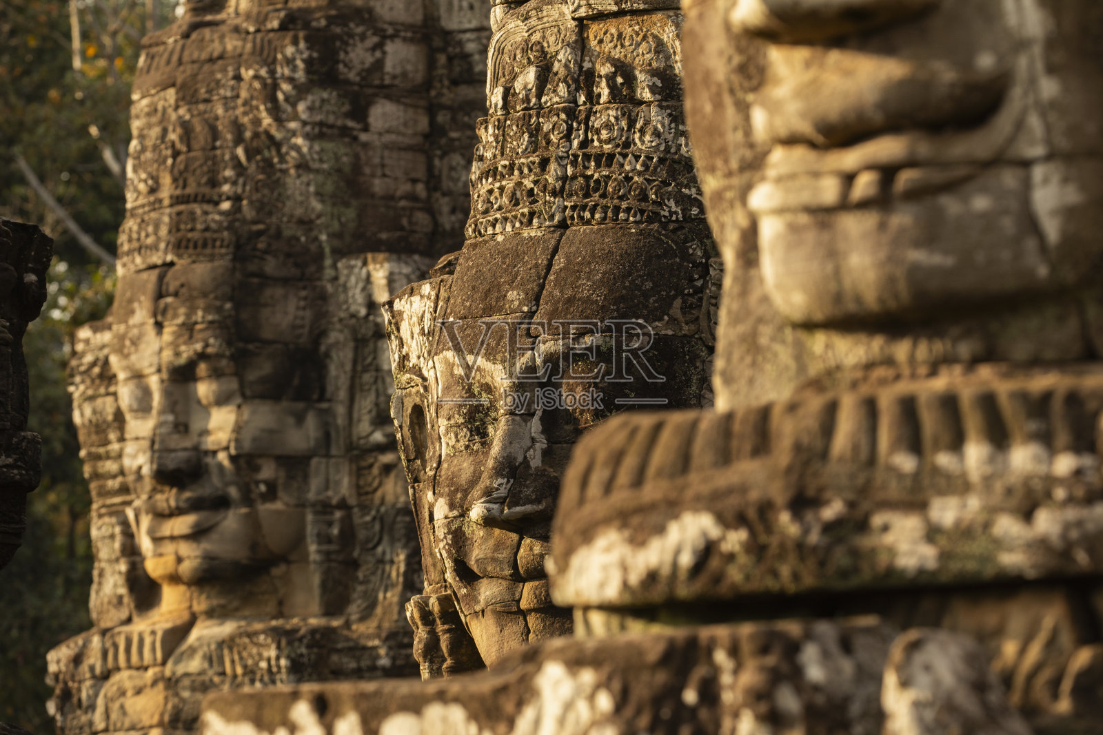 柬埔寨吴哥，在夕阳的余晖照耀下，巴戎庙里雕刻着神秘的石面。照片摄影图片