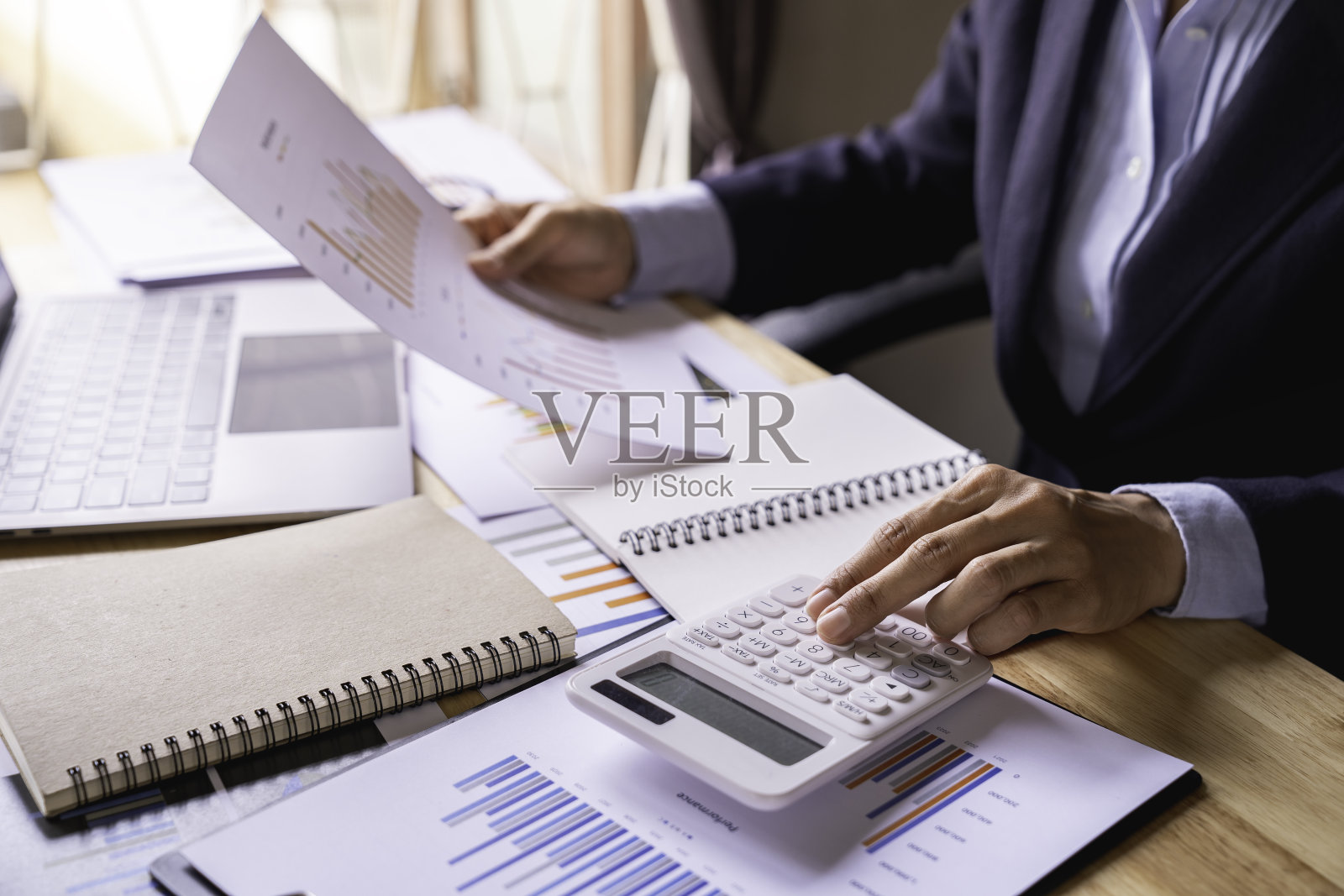 商务人员使用计算器按硬币和桌上的恒温器计算发票，分析财务数据。用计算器计算，纳税，银行账户余额照片摄影图片