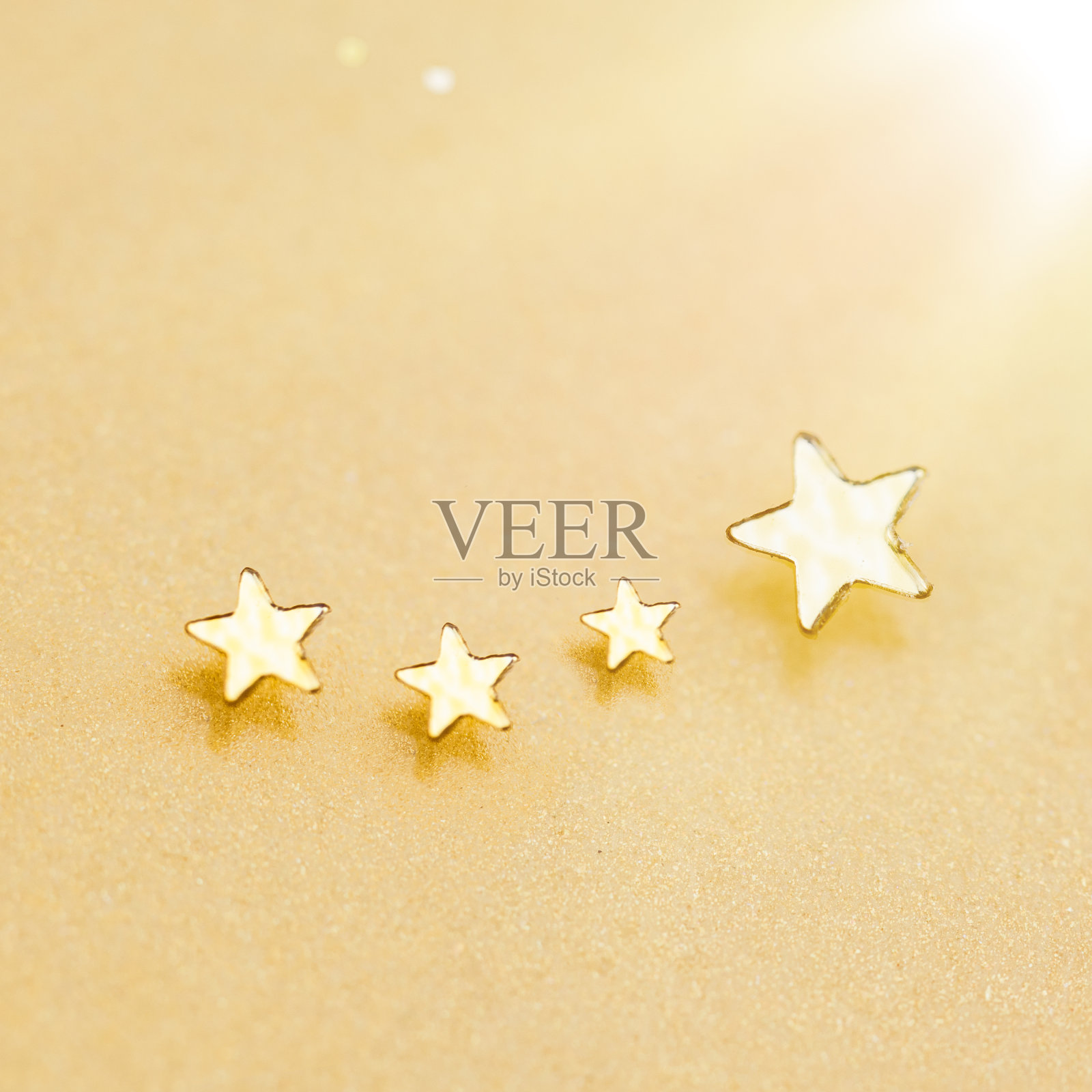 圣诞金色的星星在闪亮的金色背景。节日闪闪发光的灯光。闪闪发光的流星与星尘轨迹。照片摄影图片