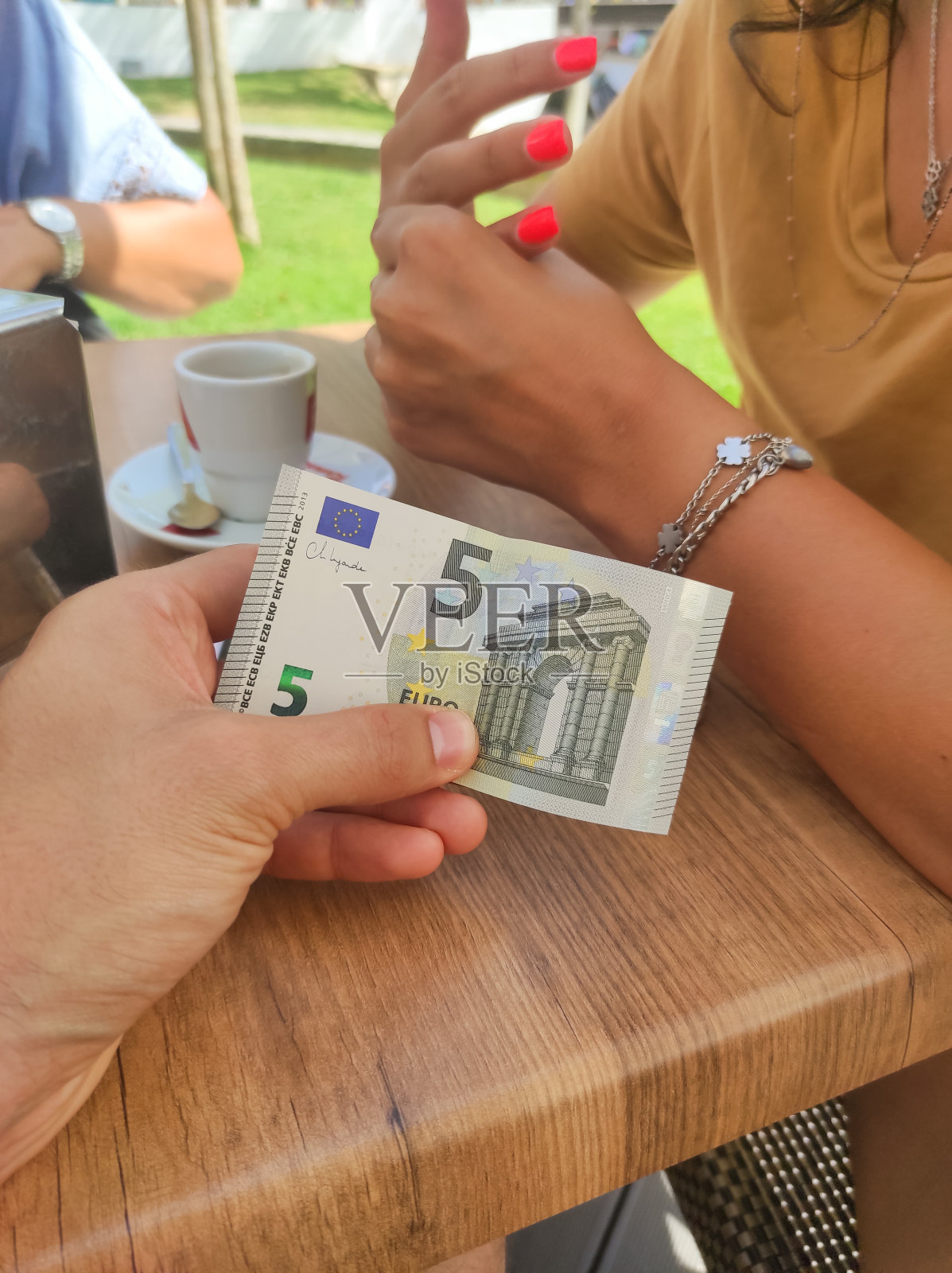 一名男子在咖啡馆用5欧元纸币付款照片摄影图片