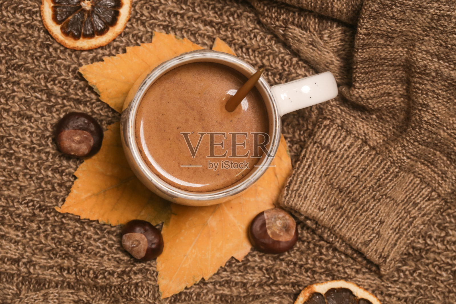 舒适的冬季生活方式概念。一杯热饮，穿着暖和的针织衣服。照片摄影图片