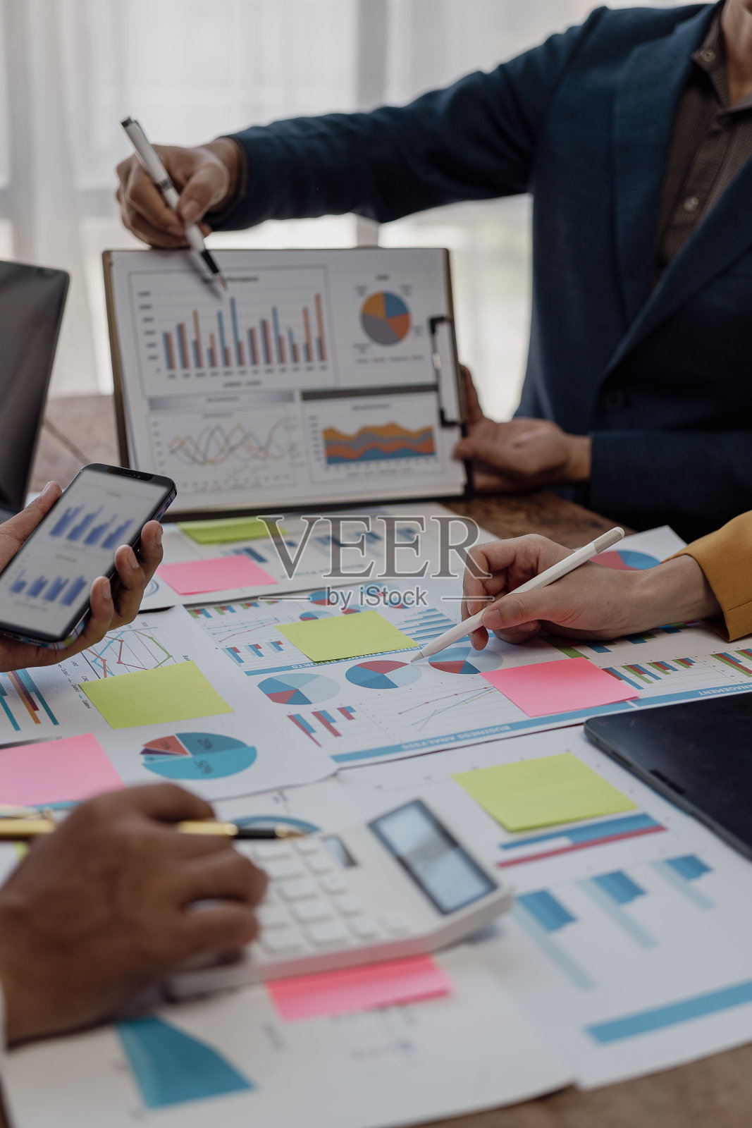 企业财务分析师在公司会议上讨论投资项目规划时的纵向形象，表现出团队合作的成功。特写照片照片摄影图片