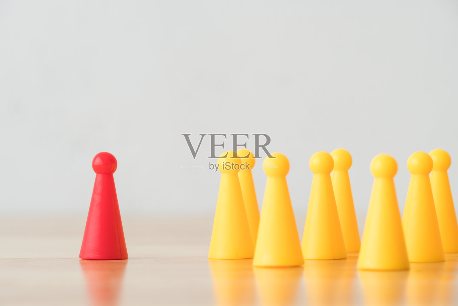 领导不同于人群，在木桌上配以白墙背景和复制空间。照片摄影图片