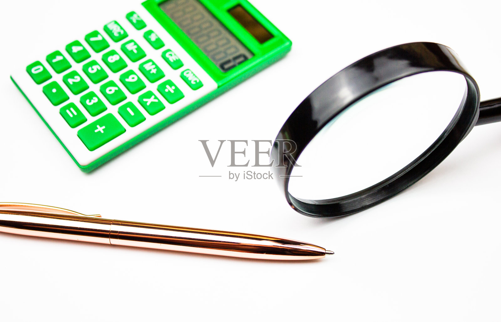 计算器笔和放大镜在一个白色的背景。会计、金融和经济概念。照片摄影图片