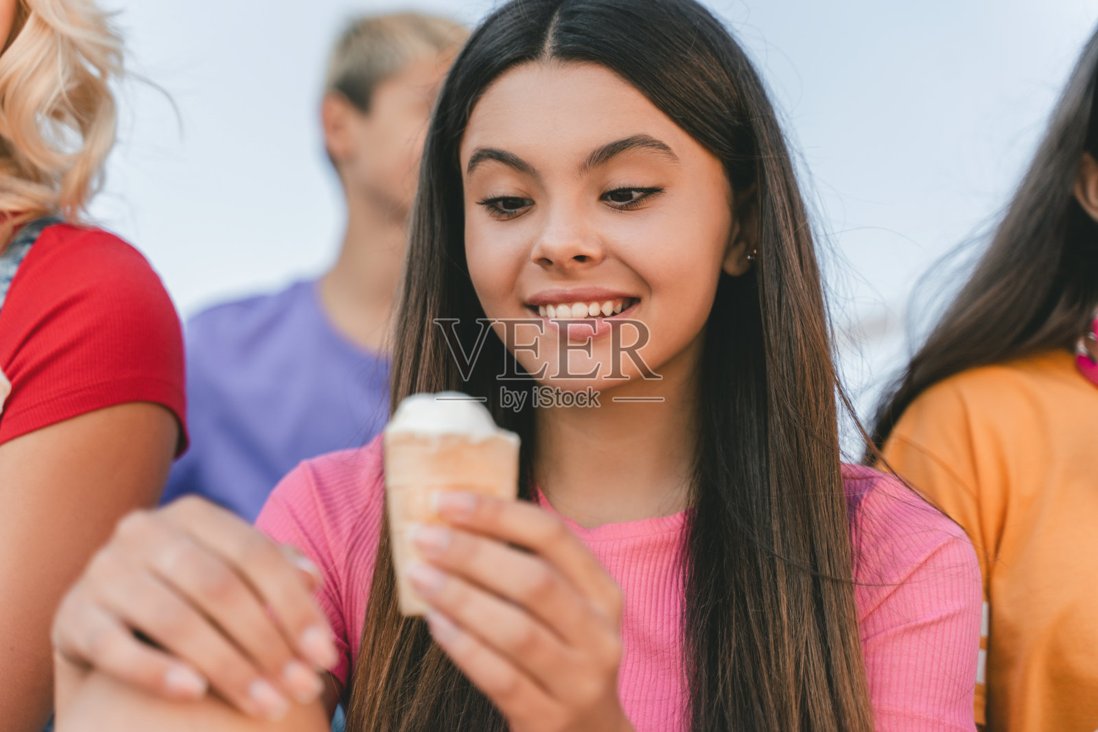 美丽的微笑少女的肖像，拿着，吃冰淇淋，美味的甜点在城市街道上照片摄影图片
