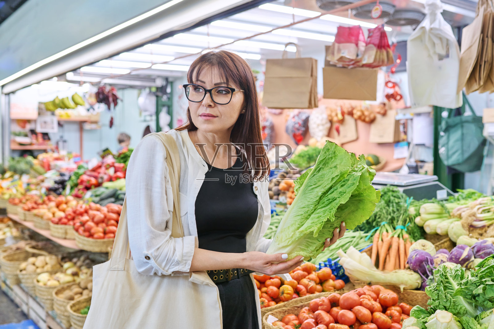 成年妇女在农贸市场选购生菜丛照片摄影图片