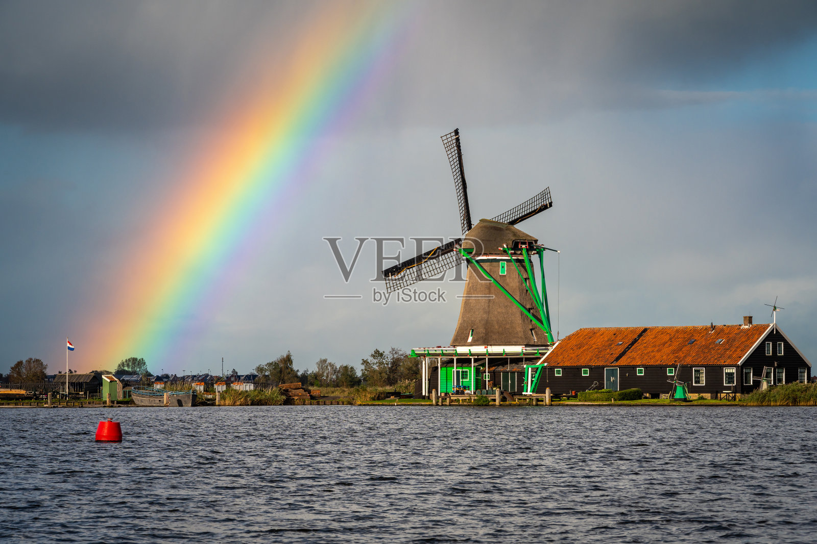 典型的荷兰风景，在赞斯山的历史风车与天空中的彩虹照片摄影图片