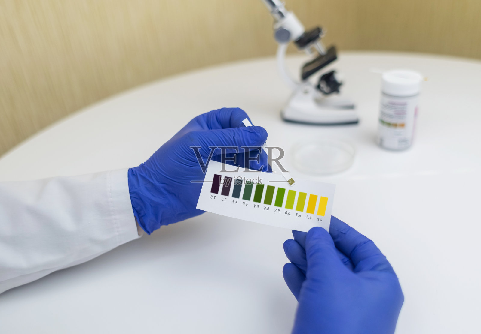 细菌性阴道炎。阴道ph值诊断。用来测量酸度是否正常的刻度。正常酸度以颜色表示，必须与标准酸度进行比较。实验室和家庭照片摄影图片
